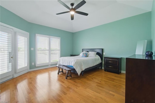 bedroom featuring a ceiling fan, vaulted ceiling, baseboards, light wood-style floors, and access to outside