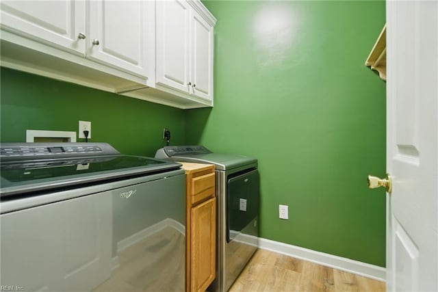 laundry room with independent washer and dryer, baseboards, light wood finished floors, and cabinet space