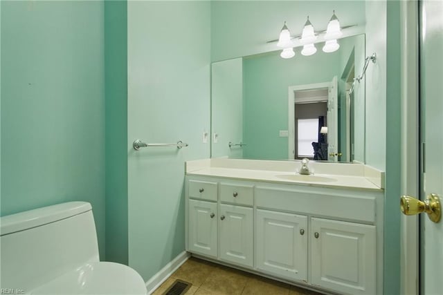bathroom with vanity, toilet, tile patterned floors, baseboards, and visible vents
