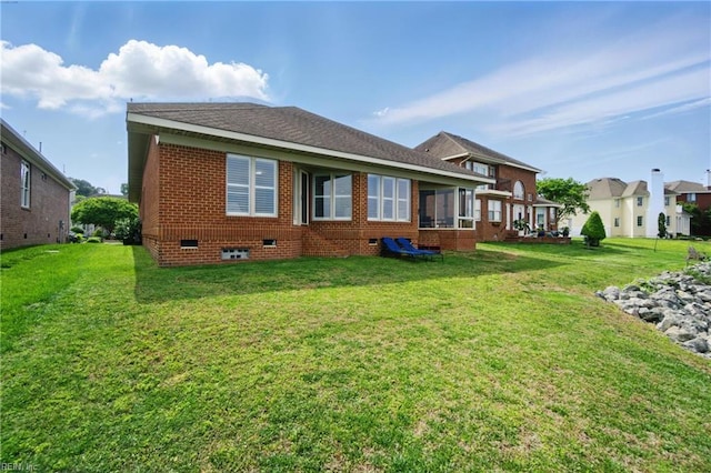 back of property with a lawn, crawl space, and brick siding