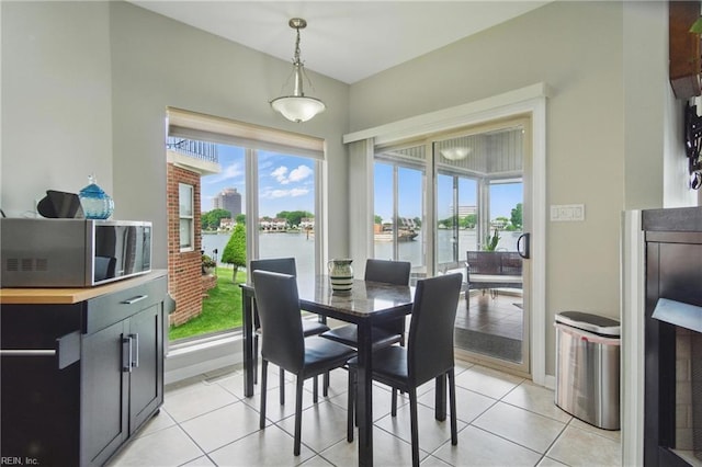 dining room with a water view and light tile patterned floors