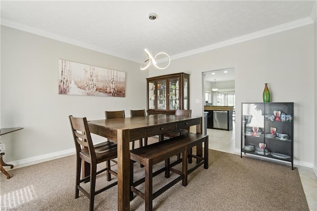 dining space with crown molding, baseboards, an inviting chandelier, and light colored carpet