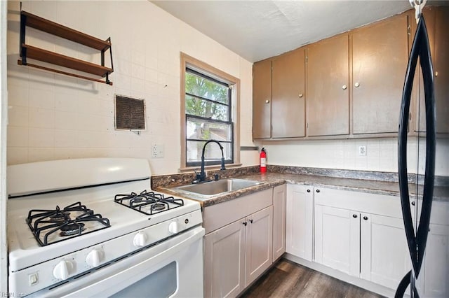 1 Polaris St, Hampton, VA 23669 - kitchen with dark wood-style flooring, open shelves, a sink, freestanding refrigerator, and white gas stove