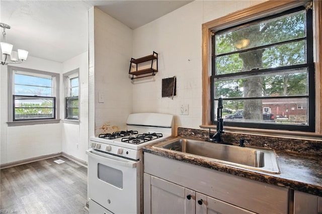 1 Polaris St, Hampton, VA 23669 - kitchen with an inviting chandelier, wood finished floors, white gas range, a sink, and decorative light fixtures