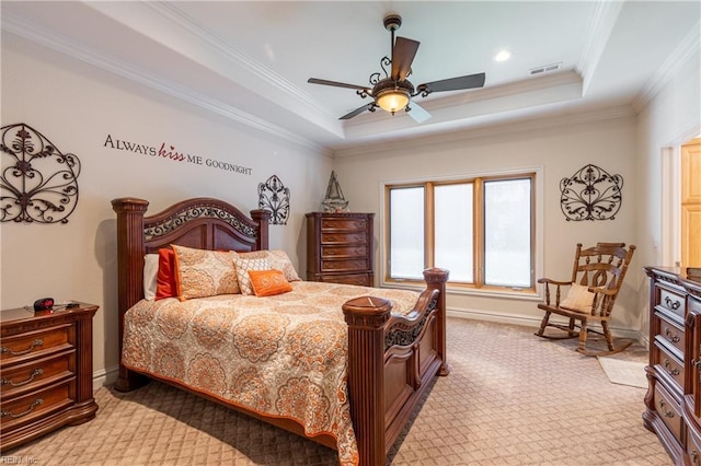 bedroom featuring light colored carpet, a tray ceiling, visible vents, and ornamental molding