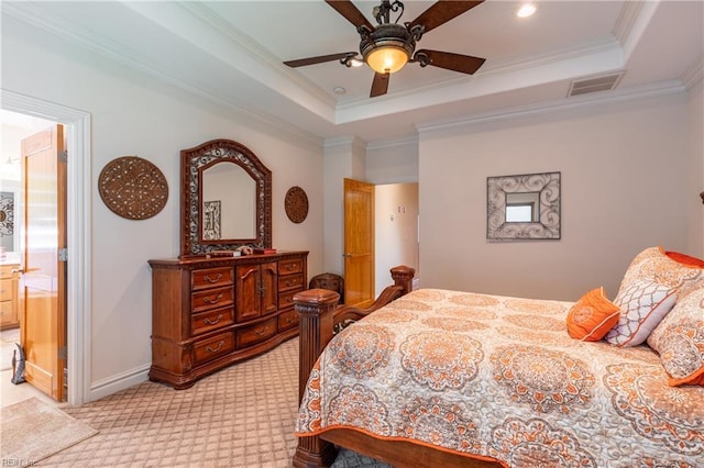 bedroom featuring visible vents, ornamental molding, light carpet, ensuite bathroom, and a raised ceiling