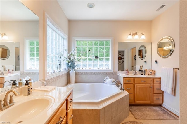 bathroom featuring a sink, tile patterned flooring, a bath, and visible vents