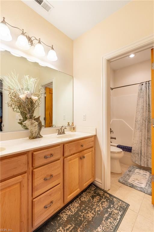 full bathroom with visible vents, double vanity, toilet, tile patterned floors, and a sink