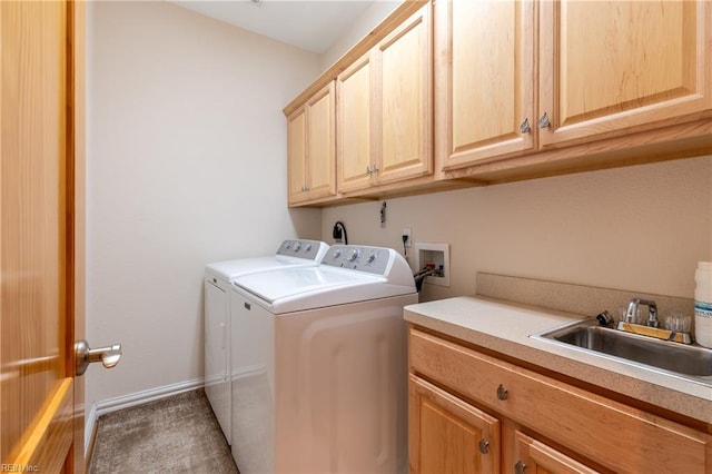 clothes washing area featuring cabinet space, separate washer and dryer, baseboards, and a sink