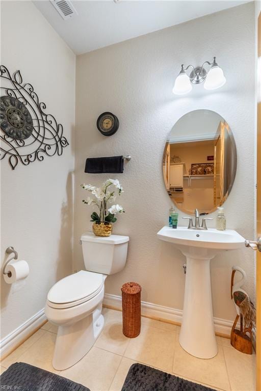 bathroom featuring visible vents, baseboards, tile patterned floors, and toilet