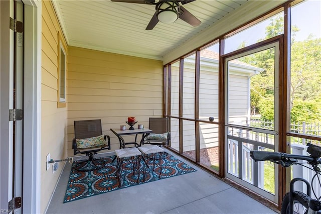 sunroom / solarium featuring plenty of natural light and a ceiling fan