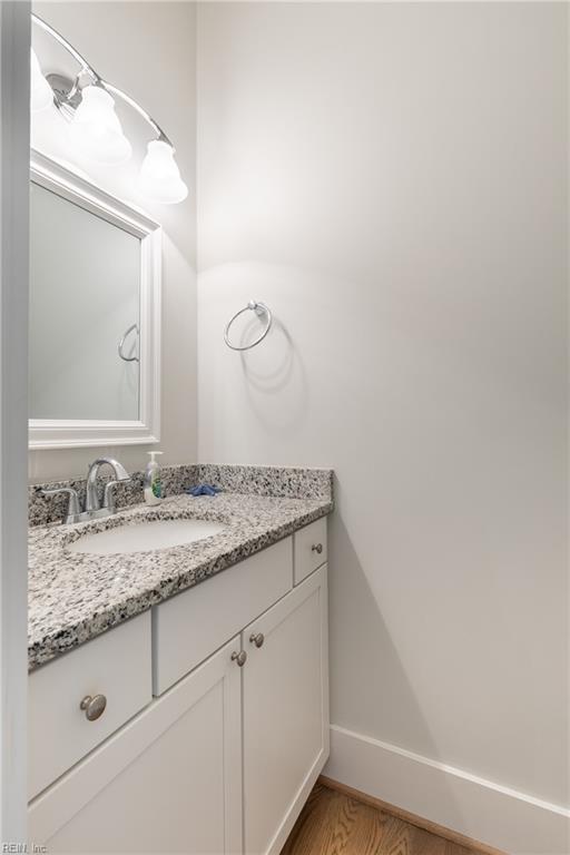 bathroom with vanity, baseboards, and wood finished floors