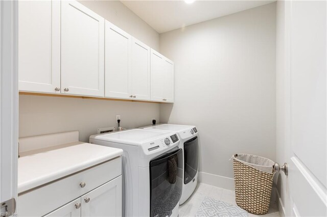 laundry area with baseboards, cabinet space, and washer and clothes dryer