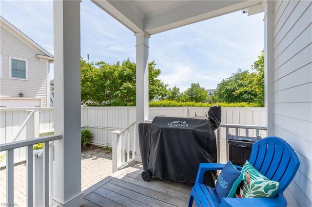 wooden deck with area for grilling and fence