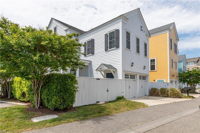 view of home's exterior featuring a garage, fence, and concrete driveway