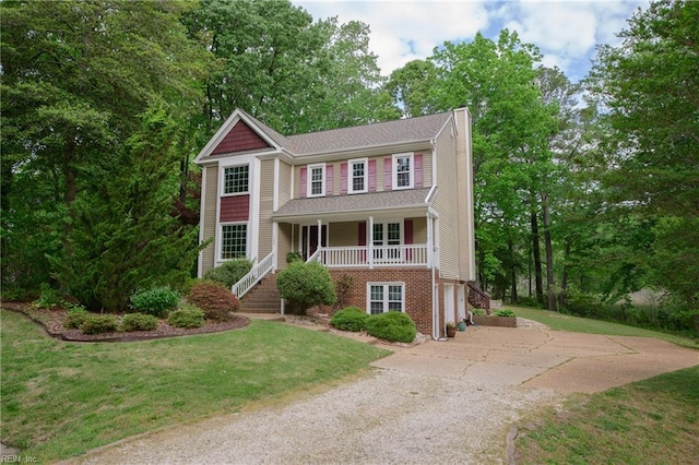 traditional-style home with an attached garage, stairway, a chimney, concrete driveway, and covered porch