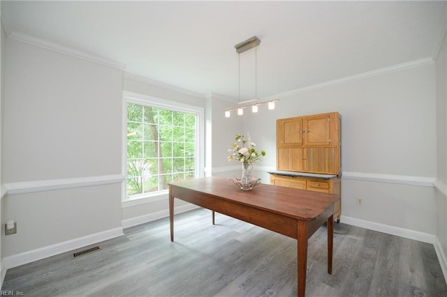 dining area featuring visible vents, ornamental molding, baseboards, and wood finished floors