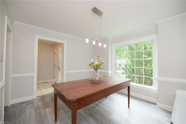 dining space featuring crown molding, baseboards, and wood finished floors