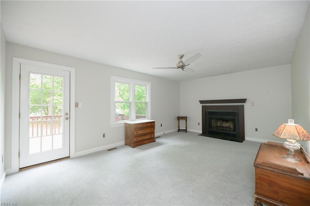 living room with carpet flooring, ceiling fan, baseboards, a fireplace with flush hearth, and visible vents