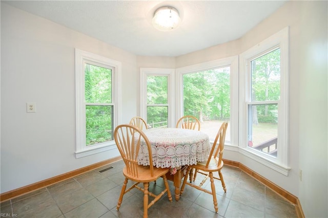 tiled dining area featuring visible vents, baseboards, and a wealth of natural light