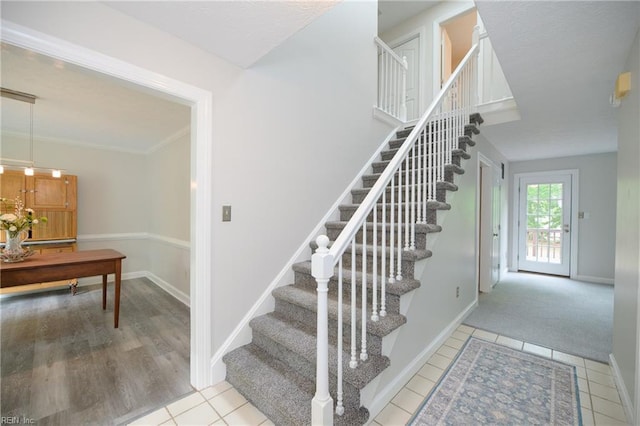 stairs featuring baseboards and tile patterned flooring