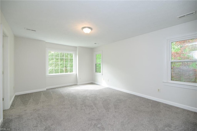 carpeted empty room with baseboards and visible vents