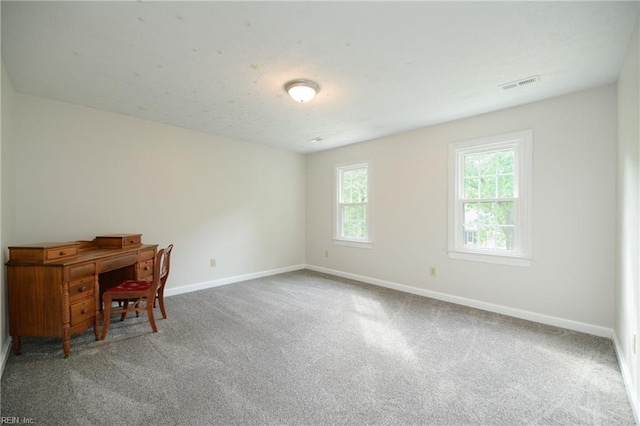 unfurnished office with carpet flooring, baseboards, and visible vents