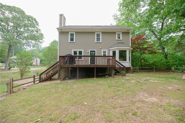 rear view of property featuring a lawn, a fenced backyard, a wooden deck, and stairway