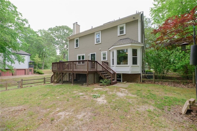 back of property featuring fence, a wooden deck, stairway, a chimney, and a lawn