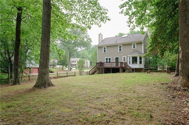 rear view of house with stairway, a yard, fence, and a chimney