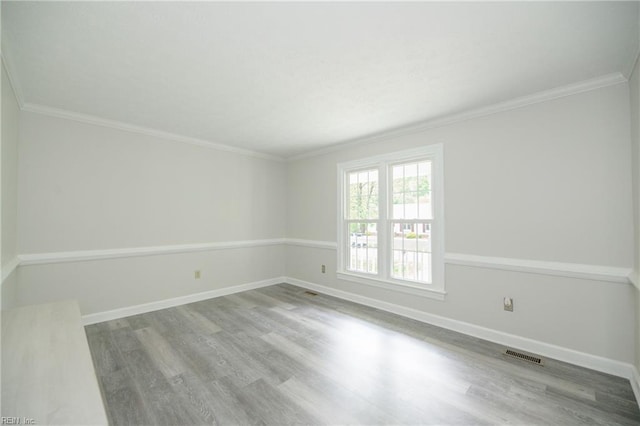 empty room with visible vents, baseboards, and wood finished floors