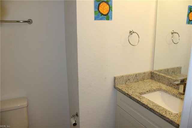 half bathroom with vanity and toilet