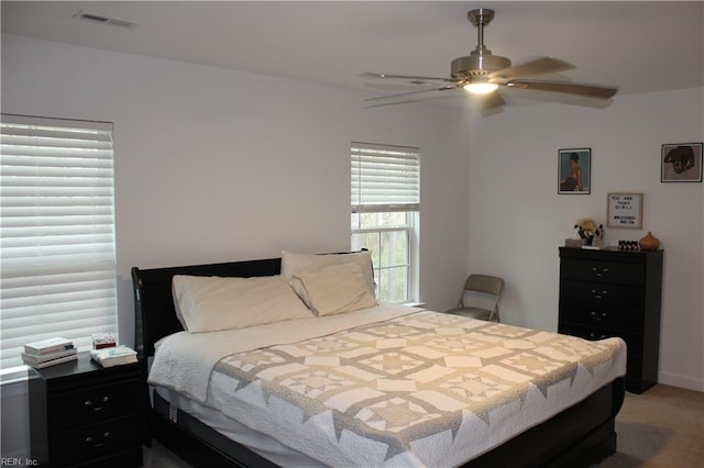 bedroom with a ceiling fan, light colored carpet, and visible vents