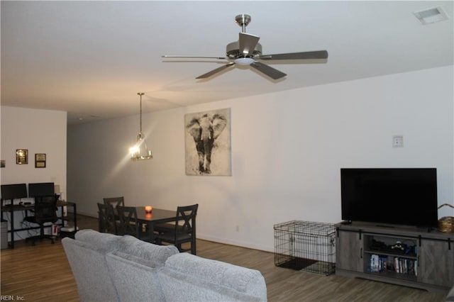 living room with baseboards, a ceiling fan, wood finished floors, and visible vents