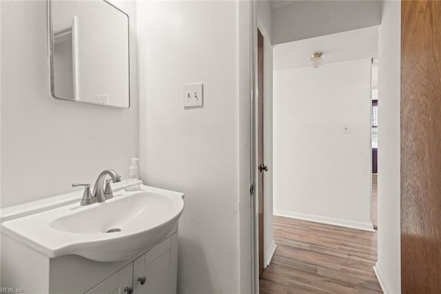 bathroom featuring vanity, baseboards, and wood finished floors