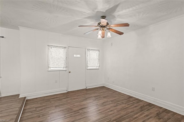 empty room featuring baseboards, a ceiling fan, and wood finished floors