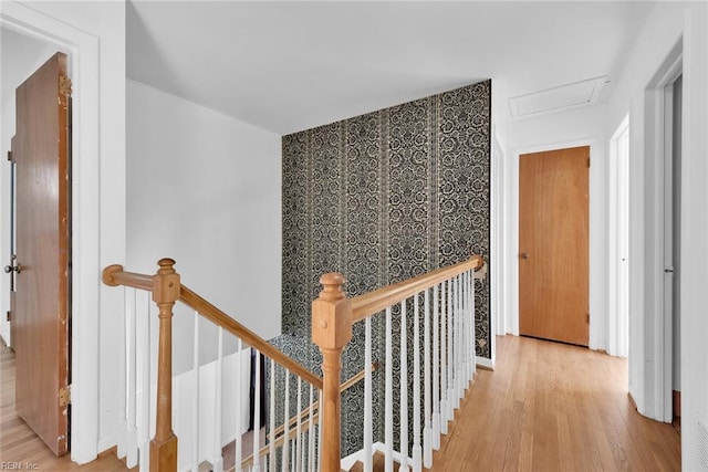 hallway featuring an upstairs landing, wood finished floors, and attic access