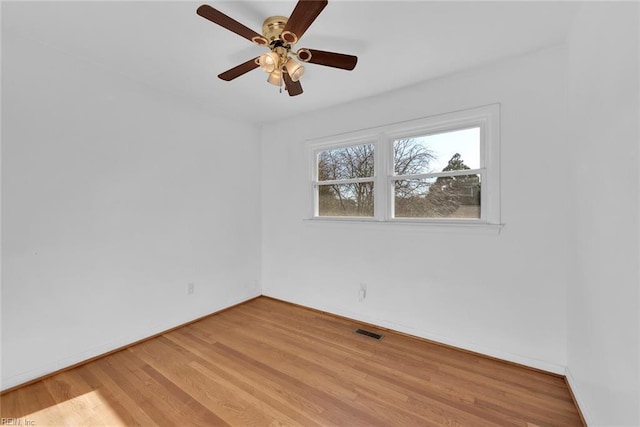 empty room featuring baseboards, a ceiling fan, light wood-style flooring, and visible vents
