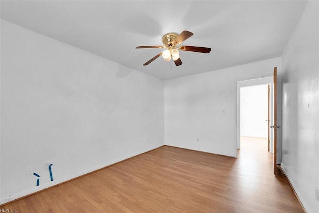 empty room featuring baseboards, ceiling fan, and light wood finished floors