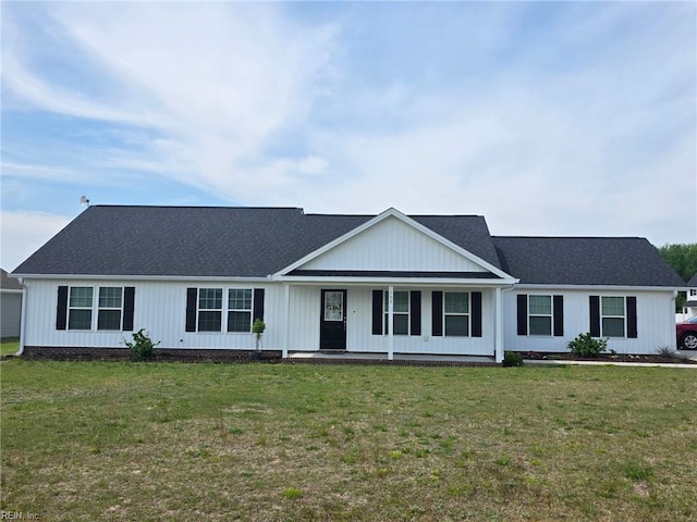 view of front of house with covered porch, roof with shingles, and a front lawn