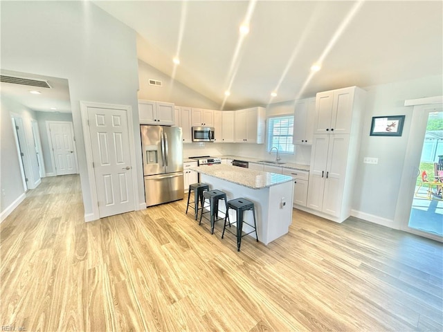 107 Mill Creek Rd, Edenton, NC 27932 - kitchen featuring appliances with stainless steel finishes, a sink, a kitchen island, light wood finished floors, and white cabinetry