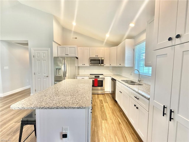 107 Mill Creek Rd, Edenton, NC 27932 - kitchen featuring stainless steel appliances, a sink, vaulted ceiling, light wood finished floors, and a center island