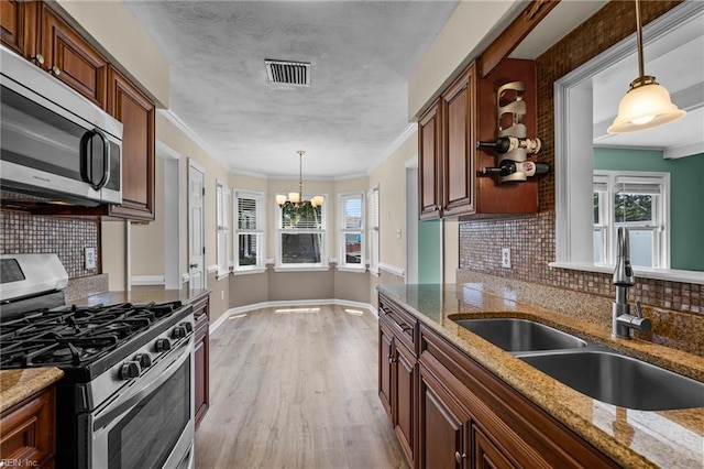1101 Revelstroke Ct, Virginia Beach, VA 23454 - kitchen featuring appliances with stainless steel finishes, a sink, a chandelier, light wood finished floors, and tasteful backsplash