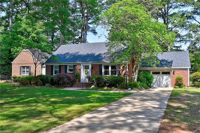 single story home featuring a garage, concrete driveway, a front yard, and brick siding