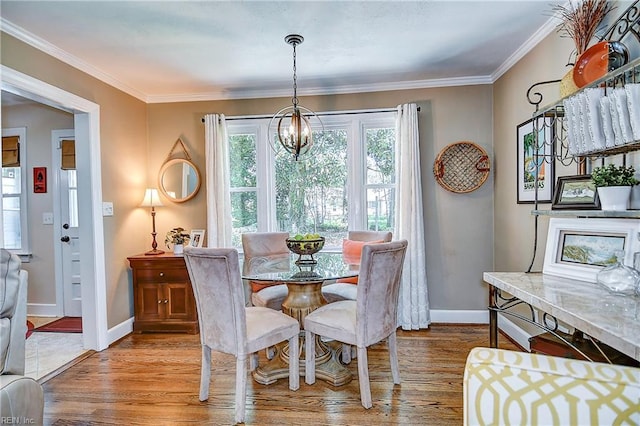 dining area with baseboards, a chandelier, and wood finished floors
