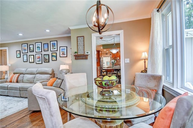 dining space featuring ornamental molding, recessed lighting, and wood finished floors