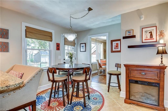 dining area with baseboards, plenty of natural light, and light tile patterned floors