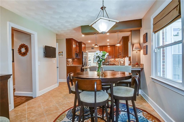 dining room featuring baseboards, recessed lighting, and light tile patterned floors