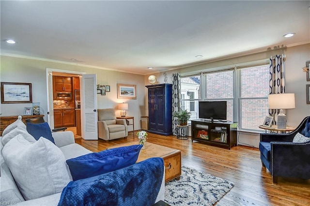 living room with crown molding, recessed lighting, and wood finished floors