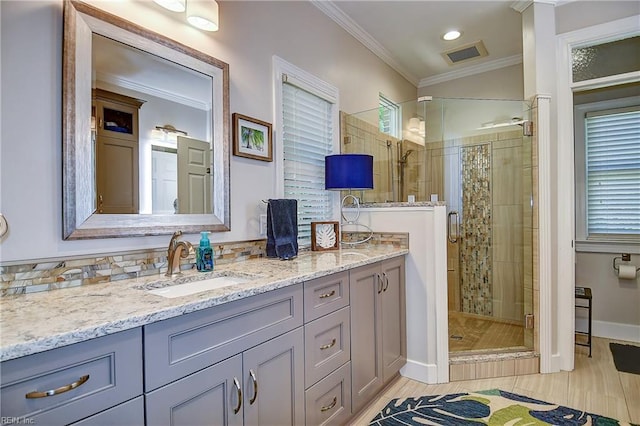 bathroom with visible vents, crown molding, vanity, a shower stall, and a wealth of natural light